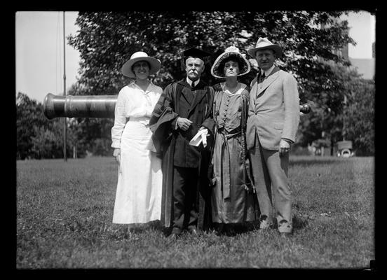 Commencement, two women, seven men with Dr. Benjamin Ide Wheeler in front of cannon