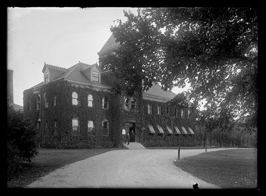 Mechanical Hall, striped awnings, two men in doorway, hitching posts