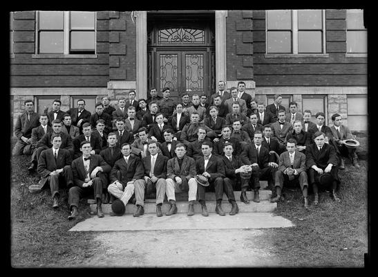 Student group, Agricultural Society, men, one woman, in front of Agricultural Building (Scovell Hall), hat on foot of second from left