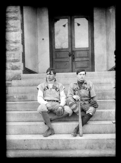 Two baseball players seated on steps