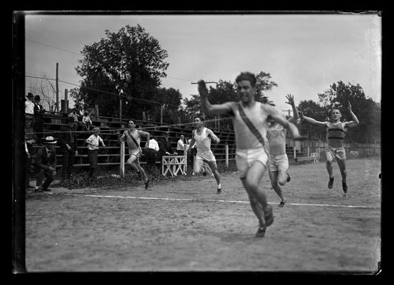 Track meet, winner of race with four close behind