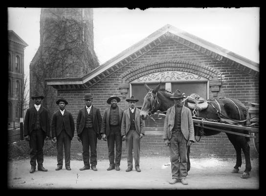 Six janitors and horse and wagon in front of heating plant, We Are Seven