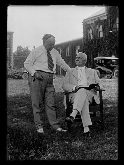 Professor M.A. Cassidy in chair with F. Paul Anderson standing Mechanical Hall in background