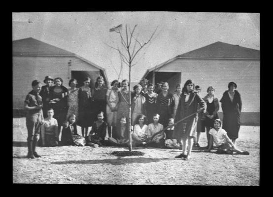 Elementary school students planting a tree