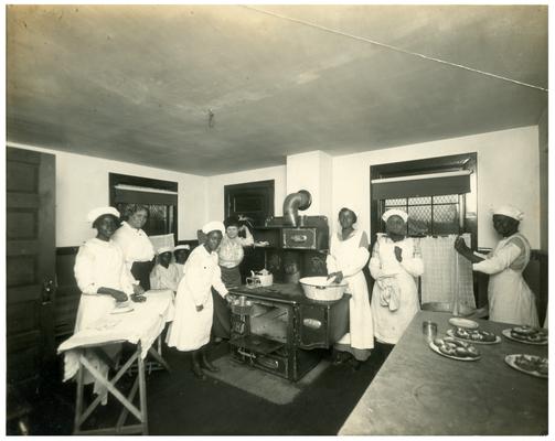 Group portrait of Maddoxtown students and Nannie Faulconer (1865?-1940) in the school kitchen. (Two copies)