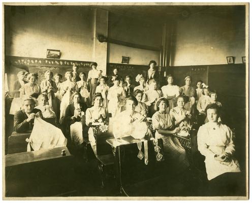 Group portrait of Picadome girls' sewing class with Nannie Faulconer (1865?-1940). Handwritten on verso, Fayette County Schools, one of the Picadome sewing classes