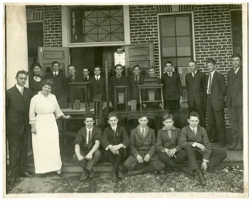 Group portrait of Picadome boys exhibiting woodwork with Nannie Faulconer (1865?-1940), Margaret McCubbing, and instructor, Orville Croder. Handwritten on verso, Articles made by the Manual Class of a Fayette County rural school. Notice the happy face of the boys