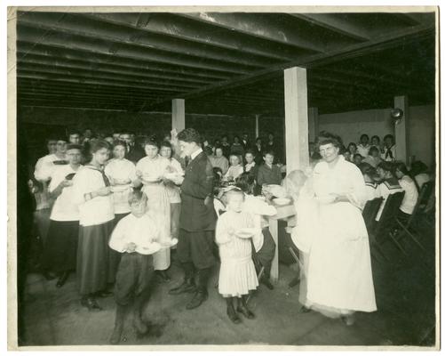 Picadome students eating lunch with Nannie Faulconer (1865?-1940). Handwritten on verso, Picadome serving hot lunch