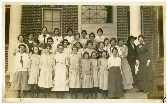 Group portrait of Picadome girls on school steps with Nannie Faulconer (1865?-1940) and Margaret McCubbing. Handwritten on verso, Class at Picadome, Mrs. Nannie G. Faulconer Supt. Miss Margaret McCubbing Prin