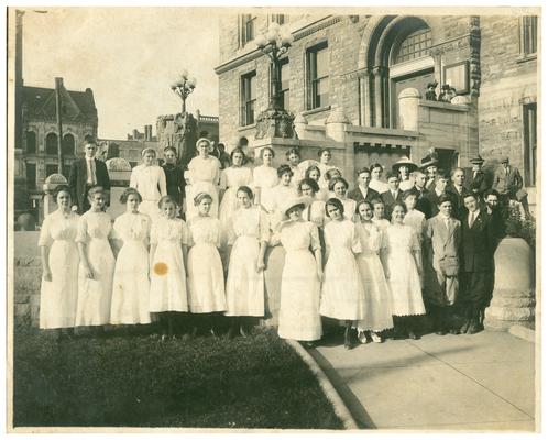 Group portrait of the graduating class of 1918 with Nannie Faulconer (1865?-1940) at the Fayette County Court House. (Two copies)
