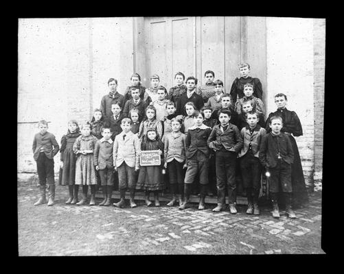 Students outside Bryan Station with Miss Lizzie Barkley, teacher (Two copies)