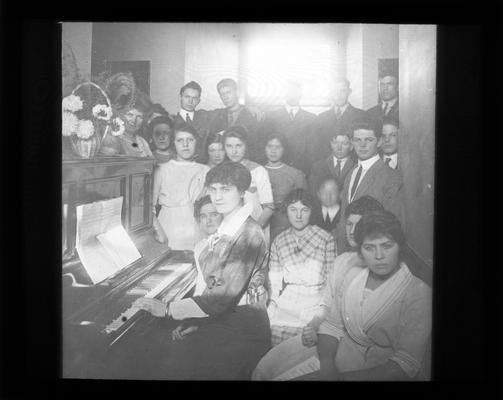 Mrs. Sullivan at the piano with students (Mrs. Nannie Faulconer is next to the flowers)