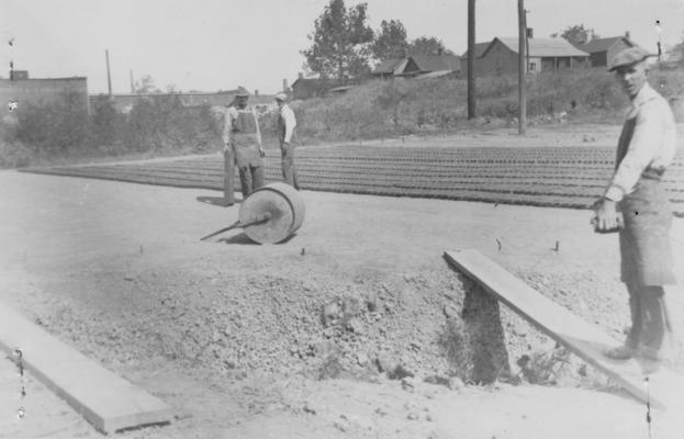 Project #1-73-27-68 District 1, Branch District 3: Photograph 3 in a series showing the various steps in manufacturing brick to be used in building a 10' wall around the Keiler Athletic Field in Paducah, KY. After bricks are molded, they are placed in lines to dry