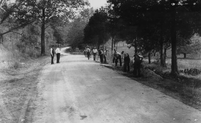 Project #249 District 6: Reconstruction of the Mt. Washington Road. This is one of the several projects on Echo Trail, a scenic highway which circles the outer edge of the county. This project involves the widening of the present 10' bituminous surface to 16'. Additional stone base will be placed and the old surface scarified before surfacing with 75 pounds per square yard treatment. Another view of same road. Excavating trench to receive base stone for widening