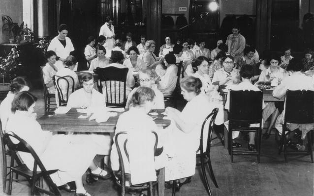 Project #205 District 6: Training and sewing centers. Women employed and trained to make wearing apparel and other articles. They are also taught the best methods of child care and household management. Completed garments are turned over to the sponsor for distribution. Louisville Training Work Center on the second floor of the Louisville Hotel. Photographed November 8, 1935