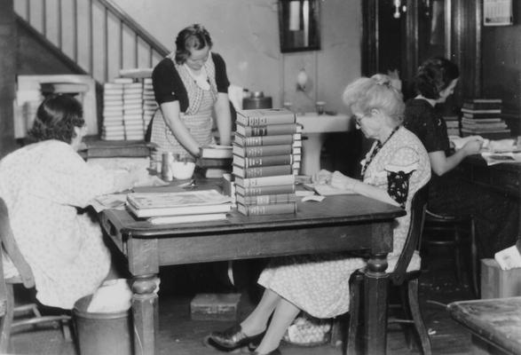 Project #716 District 6: Project No. 716 is a project where women have been assigned to mend, repair and bind books and magazines of the Louisville Free Public Library and its nine branch libraries. About 28,000 books and magazines, worn from use, would otherwise be out of circulation. Women repairing books of the Louisville Free Public Library. Photographed November 15, 1935