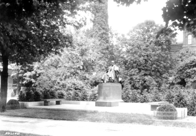 Corner of Administration Building on the left, Smoke stack /Physical Plant covered with ivy and White Hall first men's dormitory on the right with the Patterson Statue at its first location