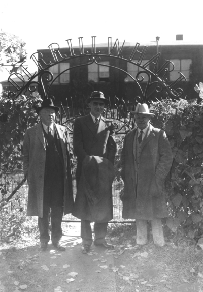 Professor James Thomas Cotton Noe, Terrill Hart? and Dean F. Paul Anderson at entrance to Dahlia garden