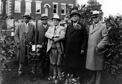 Group of men in garden with Dean F. Paul Anderson