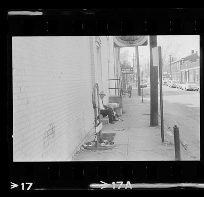 Man sitting on stoop, Man working on a door