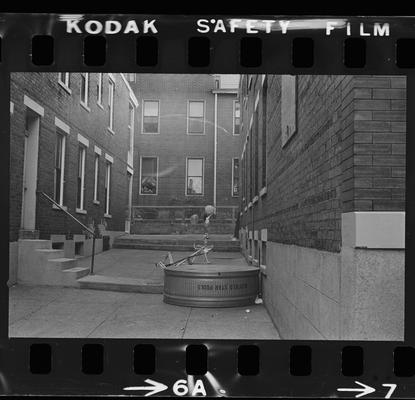 Woman and children sitting on a stoop, A back alley, A stairwell