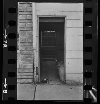 Woman and children sitting on a stoop, A back alley, A stairwell