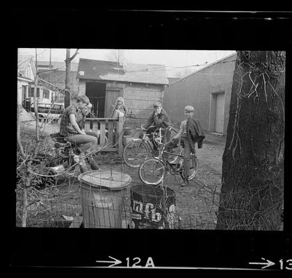 Children on bikes, Girl standing on porch, Children outside by laundry