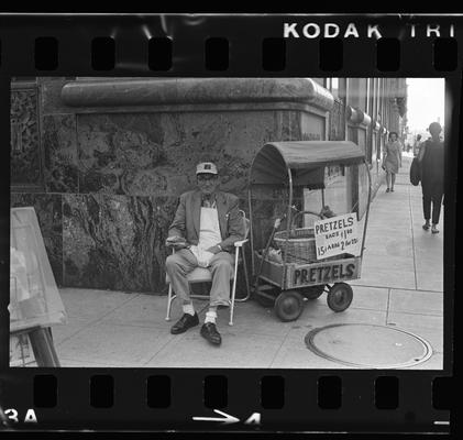 View down a street, Man selling pretzels on a corner