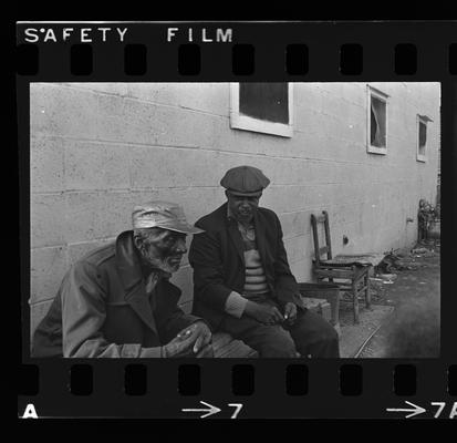 Two men seated, Child in the street