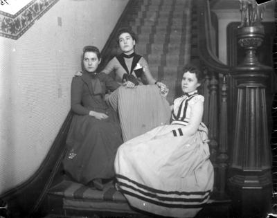 3 women sitting at the foot of the stairs