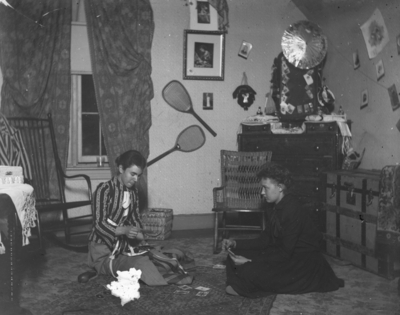 2 women sitting on the floor playing cards