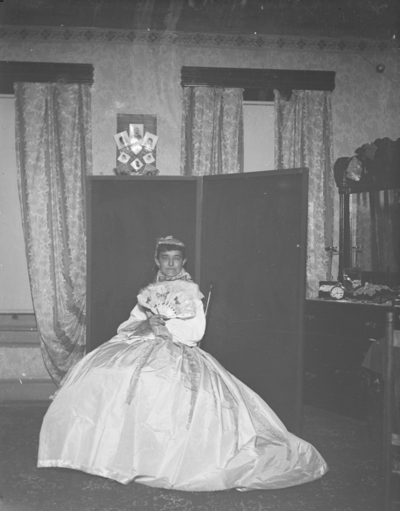 a woman sitting and holding a fan