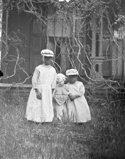 2 children standing with a statue