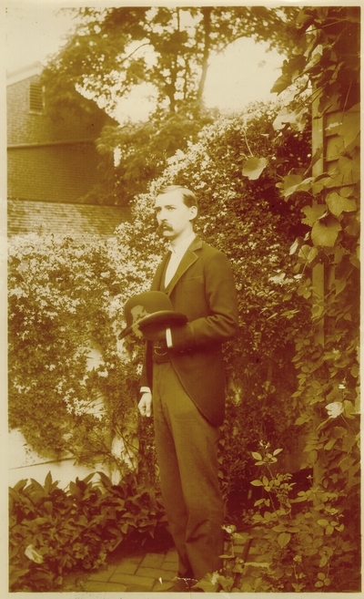 Charles Nourse Lyle standing in garden holding his hat; Exposure information on back; variant of #204
