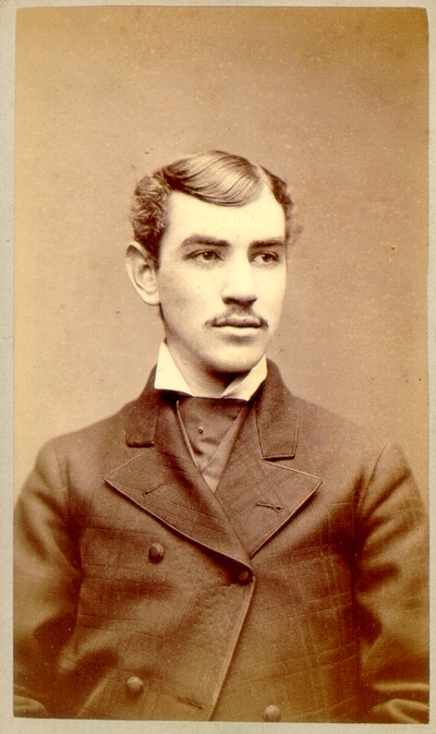 Young man with moustache wearing dark suit with plaid pattern