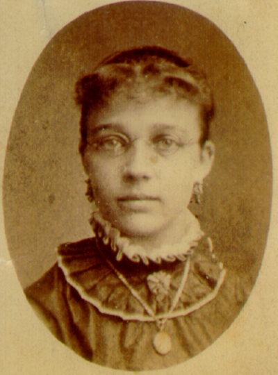 Young woman wearing dark dress and glasses; Western Female Seminary