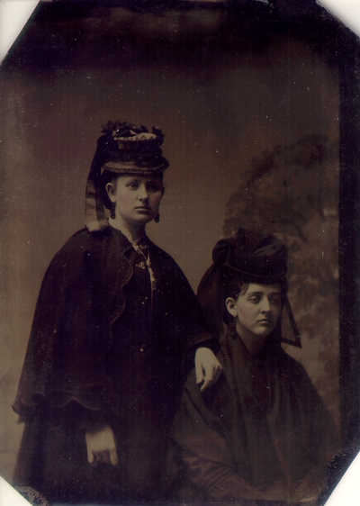 Young woman standing next to seated Lizzie Lyle; Both dressed in full dark outfitted; Quote to left of photo reads 