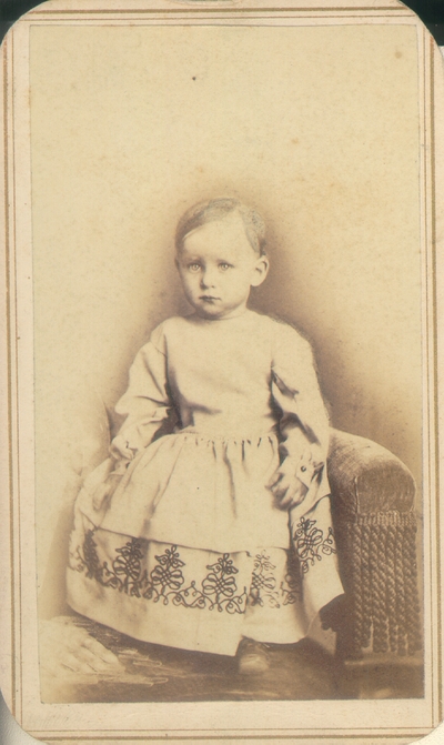 Toddler girl in nice white dress with black pattern at bottom