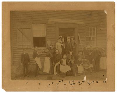 Twenty men and women standing in front of building, handwritten on back in ink                              Laboratory / at Annisquam / Mass. - / Summer of / 1886. / Photo by / Jacob Reighard (l to r)                              1. Elmer Hodgkins - Annisquam / 2. J.H. Morgan - Lexington, Ky / 3. K.E. Farrand - Detroit, Mich. / 4. Edith Guild - Boston / 5. B.P. Colton - Ottawa, Ill. / 6. Ellen Folger - Concord, N.H. / 7. May Murray - New York, N.Y. / 8. Chas. Farr - New Castle, Ind. / 9. Fanny Julian - New York City, N.Y. / 10. Alma S. Bingham - Jamaica Plain, Mass. / 11. C.P. Shoemaker Philadelphia, Pa. / 12. J.E. Reighard - La Porte, Ind. / 13. Linda E. Horns - Detroit, Mich. / 14. H. G. White - Farmington, Mass. / 15. Lemine Martin - Boston / 16. Anna Shoemaker - Philadelphia, Pa. / 17. Robert Wood - Jamaica Plain, Mass. / 18. Henry Ward - Troy, N.Y. / 19. Arthur Biffins - Albion, Mich. / 20. Evelyn Borrow - Reading, Mass