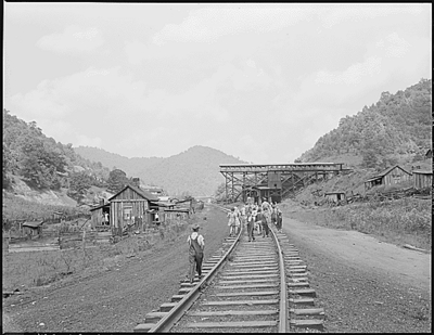 School children walk down the railroad tracks to their homes and lunches.  The mine here was abandoned after an explosion in December, 1945.  Four Mile, Bell County, KY. 9/4/46