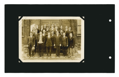 Group portrait: male students and professor on steps of building