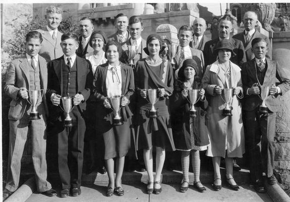 Group of young men and women with trophies