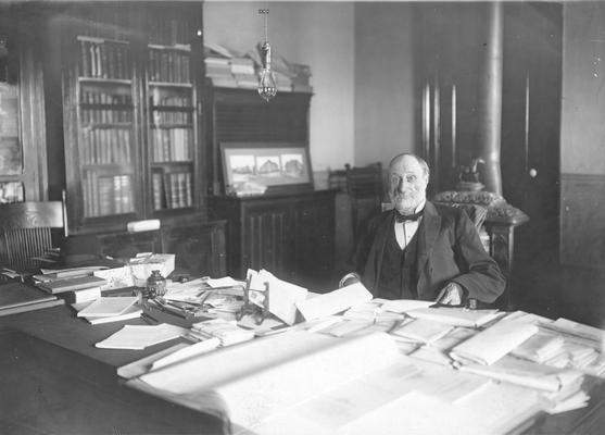 Administration Building, interior, President James K. Patterson, sitting at his desk in the Administration Building President's office, This framed print enlargement is hanging in room 204, Margaret I. King Library. (University Archives and Records Program)