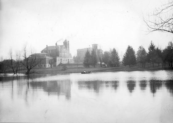 Scene of the lake and man and woman in canoe and the campus, circa 1903 - 1919