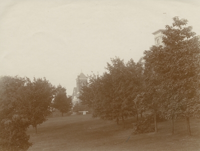 2 buildings off in the distance, one building is mostly hidden behind trees