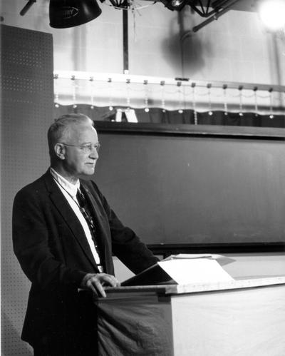 Man on studio set, facing cameras (George Brady)