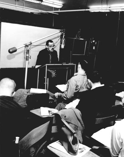 Folklore professor Dr. Bill Jansen, speaking to students in studio classroom; 