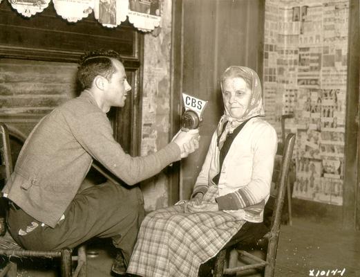 Young man holding CBS microphone head to show elderly woman