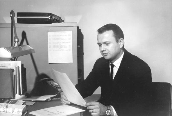 Man sitting at desk reading paper