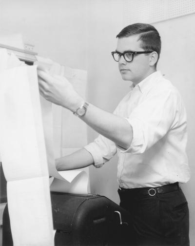 Young man reading news stories from wire service